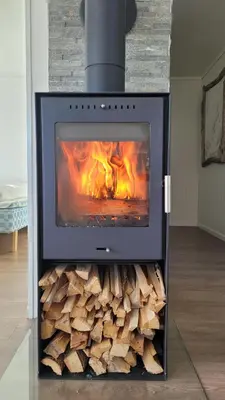 a fireplace with a pile of fire wood at Haramsøy Holiday Apartment- Island Life North in Haram