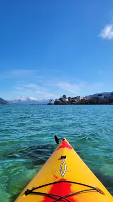 a view from the back of a yellow kayak in the water at Haramsøy Holiday Apartment- Island Life North in Haram