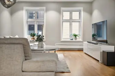 a living room with a couch and a tv at Fløyen Lux Apartment in Bergen