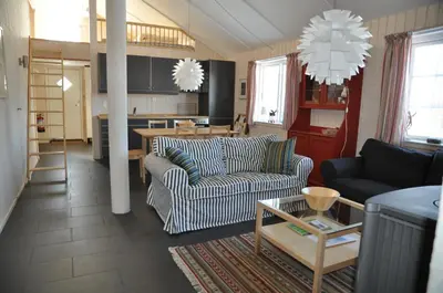 a living room with two couches and a kitchen at Gålå Fjellhytter in Gålå