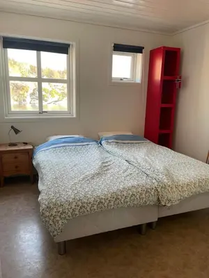a bedroom with a bed and a red shelf at Spacious apartment with view over the trondheimfjord in Vangshylla