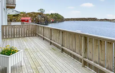 a wooden balcony with a view of the water at Beach Front Home In Smøla With Kitchen in Smøla