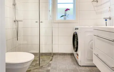 a bathroom with a toilet and a washing machine at Beach Front Home In Smøla With Kitchen in Smøla