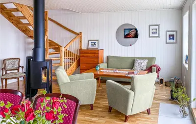 a living room with a fireplace and a table and chairs at Beach Front Home In Smøla With Kitchen in Smøla
