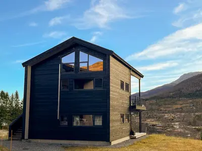 a house with a large window on the side of it at Fjellsætra Alpegrend in Sykkylven