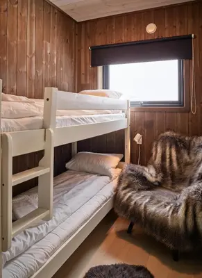 a bedroom with two bunk beds and a chair at Fjellsætra Alpegrend in Sykkylven