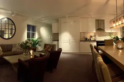 a kitchen and a living room with a table and chairs at New apartment near the lifts tourist center Trysil in Trysil