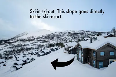 a town covered in snow with two arrows pointing to a house at The Panorama Retreat - Rindabotn Cabin in Sogndal