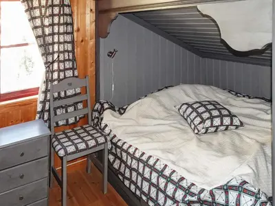 a bedroom with a bed and a chair in it at 10 person holiday home in Svingvoll-By Traum in Svingvoll