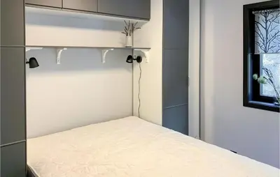 a small bedroom with a bed with a white mattress at 3 Bedroom Awesome Home In Hebnes in Hebnes