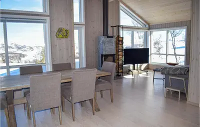 a dining room with a table and chairs and a television at Awesome Home In Rauland With Kitchen in Rauland