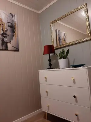 a dresser with a lamp and a mirror on it at Kleines Haus am Fjord in Sør-Eidem
