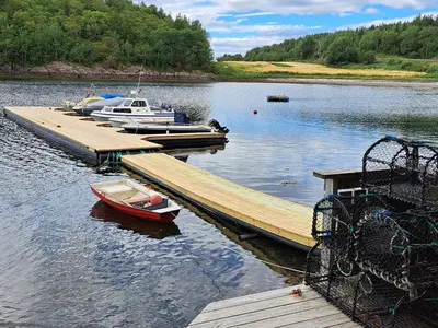 two boats are docked at a dock on a lake at Kleines Haus am Fjord in Sør-Eidem