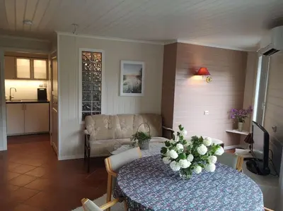 a living room with a table with flowers on it at Strøken leilighet in Åheim