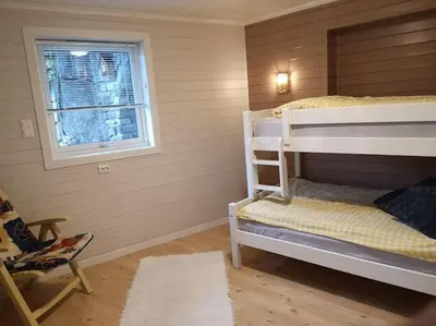 a room with two bunk beds and a window at Strøken leilighet in Åheim