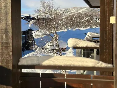 a view of a snow covered yard from a window at Bjelbølens stjernely in Beitostøl
