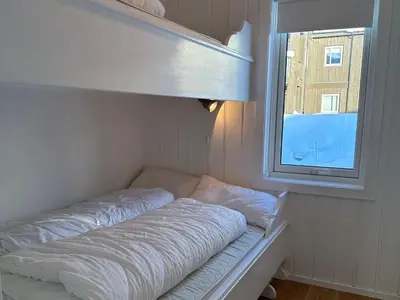 a bed in a room with a window at Bjelbølens stjernely in Beitostøl