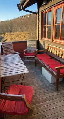 three chairs and a bench on a wooden deck at Apartment City Beitostølen in Beitostøl