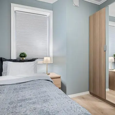 a bedroom with a large bed and a window at Holmboe Apartment in Bergen