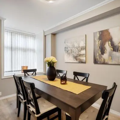 a dining room table with chairs and a vase on it at Holmboe Apartment in Bergen