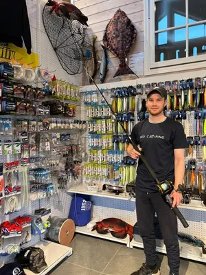 a man holding a fishing pole in a store at Bud Camping in Bud