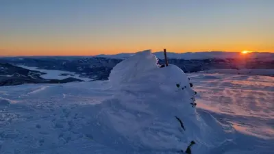 a mound of snow on top of a mountain at sunset at Heimstølen - Cabin at Sørbølfjell in Flå