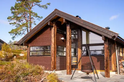 a small wooden house with a large window at Heimstølen - Cabin at Sørbølfjell in Flå