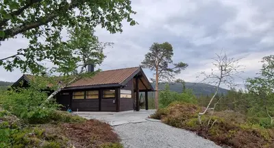 a small house on a hill with a gravel driveway at Heimstølen - Cabin at Sørbølfjell in Flå