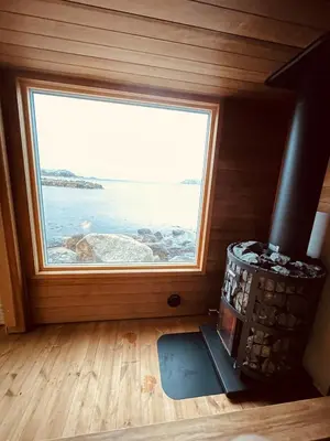 a room with a large window in a tiny house at Kråen Gard in Larsnes