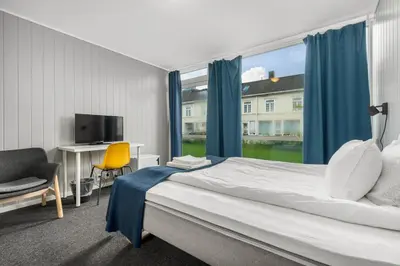 a bedroom with a bed and a desk and a window at Norpark Romutleie in Orkanger