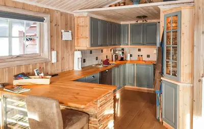 a kitchen with wooden cabinets and a wooden table at Cozy Home In Ulnes With Sauna in Ulnes