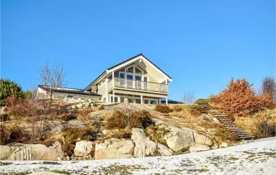 a house on top of a hill with rocks at 4 Bedroom Cozy Home In Fitjar in Fitjar