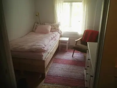 a small bedroom with a bed and a window at Nedre Skogtun cabin by Norgesbooking in Tisleidalen