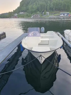 a boat is docked at a dock in the water at Leirvik i Sogn-Apartment in Leirvik