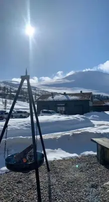 a swing in the snow with a house in the background at Gaustablikk - ski in & out apartment - Mountain View in Gaustablikk