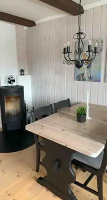 a dining room with a wooden table and a stove at Gaustablikk - ski in & out apartment - Mountain View in Gaustablikk