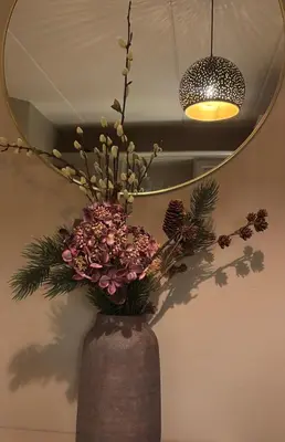 a vase filled with flowers in front of a mirror at 2 leiligheter med nydelig utsikt og hotell-følelse in Beitostøl