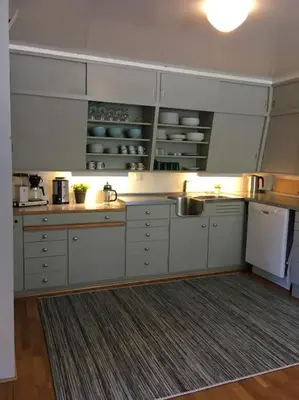 a large kitchen with white cabinets and a rug at Moonvalley Lodge - stort & koselig hus - Måndalen in Sæbø