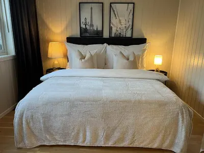 a bedroom with a large white bed with two lamps at Bratsberg Apartment - with Kitchenette and Free Parking in Trondheim