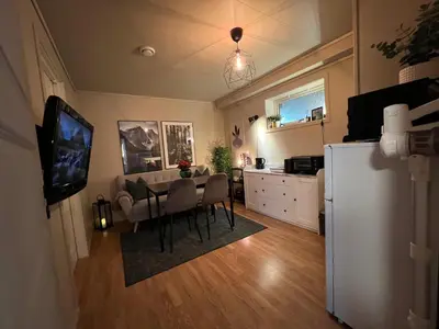 a kitchen and dining room with a table and a refrigerator at Bratsberg Apartment - with Kitchenette and Free Parking in Trondheim