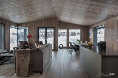 a living room with a couch and a table at Nydelig og Moderne hytte på Kikut Geilo - 6 senger, 4 soverom og jacuzzi in Geilo