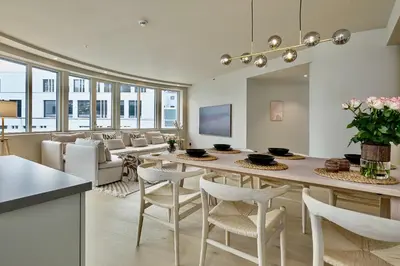 a kitchen and living room with a table and chairs at Brand new and luxurious penthouse in Bergen city centre! in Bergen