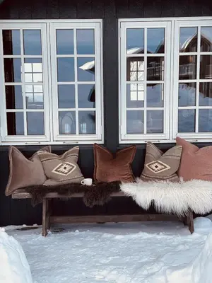 a bench with pillows sitting in front of windows at Geilo-Kikut, Ski-In, Ski-Out with Stunning Trails and Perfect Location in Geilo