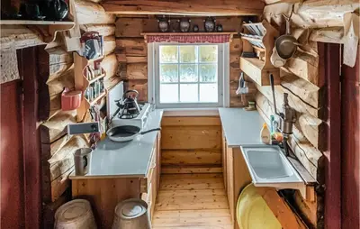 a kitchen in a log cabin with a window at Cozy Home In Vinstra With Kitchen in Vinstra