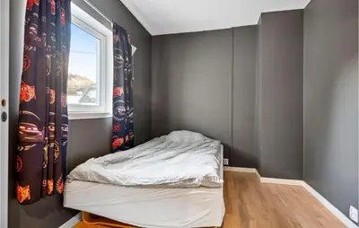 a small bedroom with a bed and a window at 3 Bedroom Awesome Apartment In Nesttun in Bergen