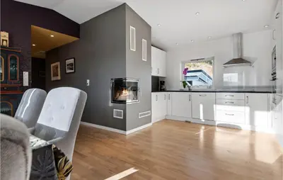 a kitchen with white cabinets and a fireplace at 3 Bedroom Awesome Apartment In Nesttun in Bergen