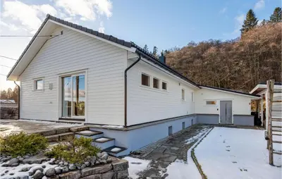 a white house with a stone driveway in front of it at 3 Bedroom Awesome Apartment In Nesttun in Bergen