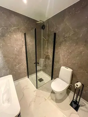 a bathroom with a shower and a toilet and a sink at Villa Gulstua in Røros