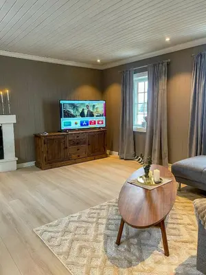 a living room with a television and a coffee table at Villa Gulstua in Røros