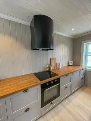 a kitchen with white cabinets and a black stove top oven at Villa Gulstua in Røros